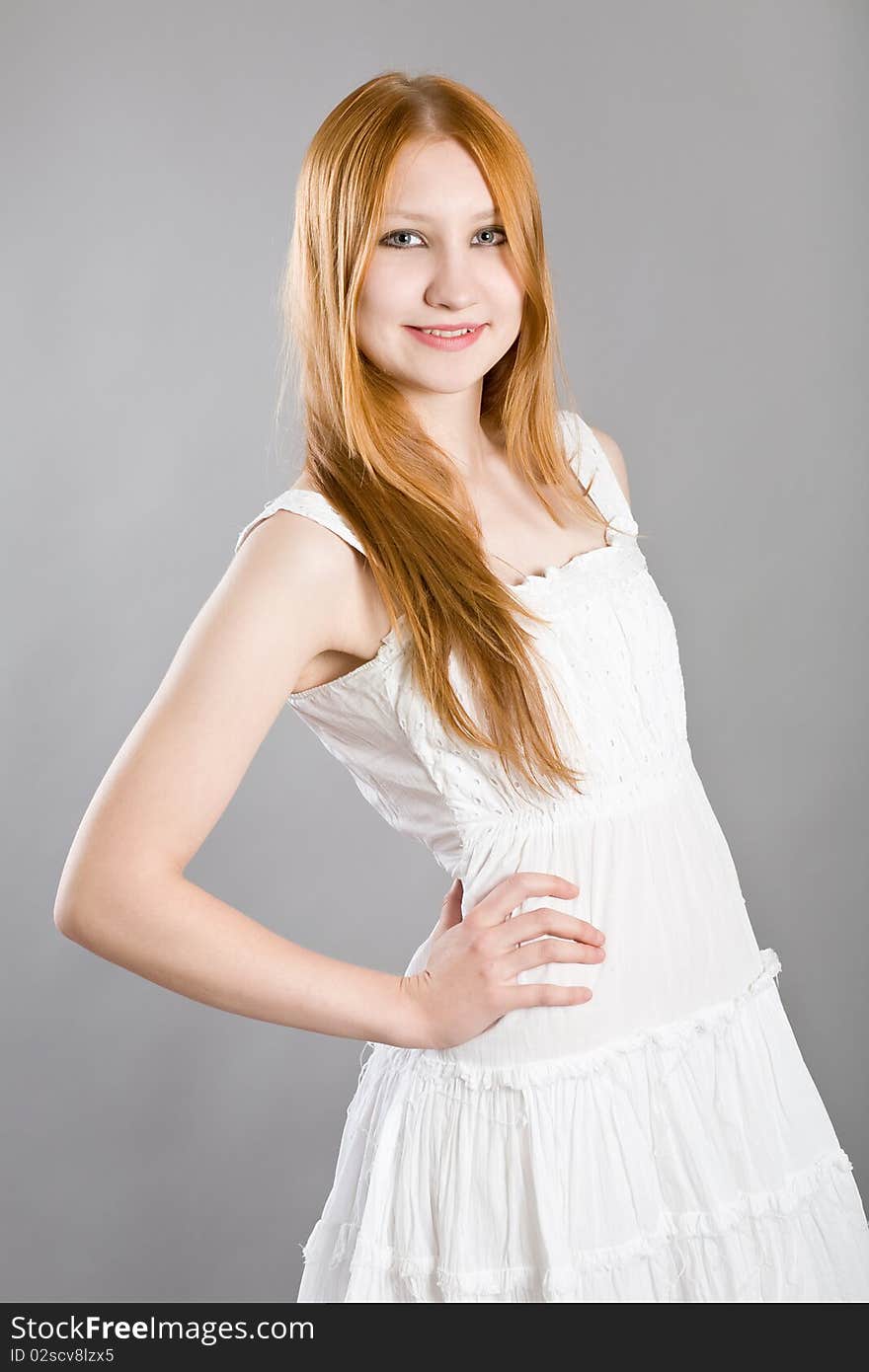 Young attractive girl in a white dress on a gray background. Young attractive girl in a white dress on a gray background