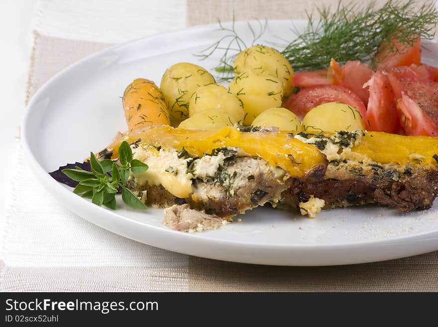 Roast pork, potatoes, tomatoes and basil on a plate. Roast pork, potatoes, tomatoes and basil on a plate