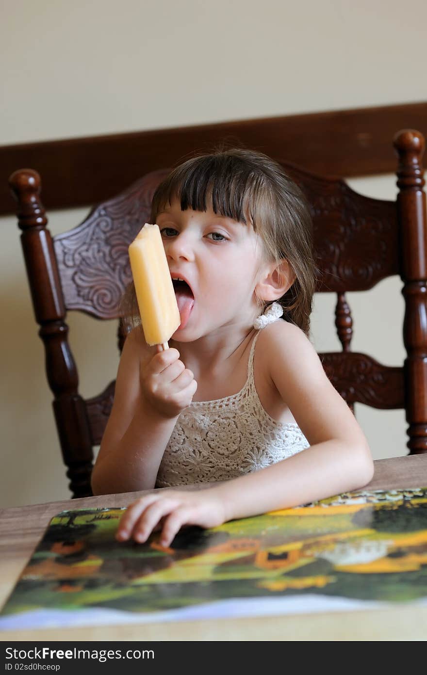 Nice toddler girl eating ice cream indoors