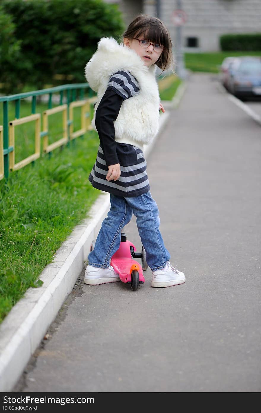 Nice litlle girl with pink scooter