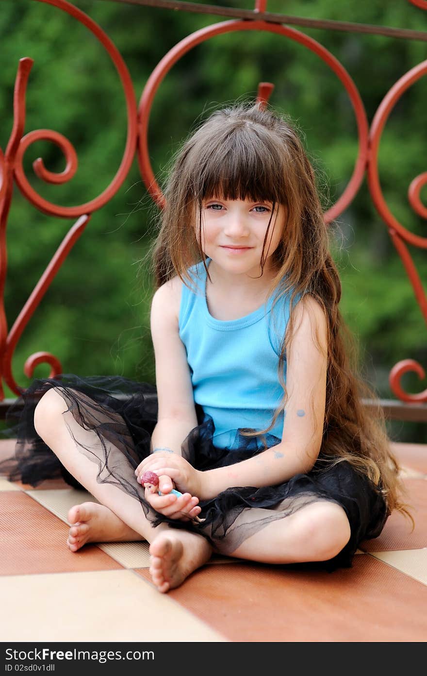 Adorable toddler girl with very long dark hair on the balcony in tutu skirt