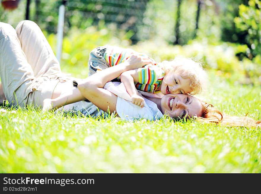 Beautiful young mother with her  daughter playing on grass . summer. Beautiful young mother with her  daughter playing on grass . summer.