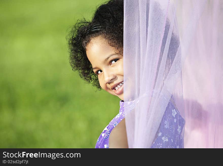 Little girl peeking from behind a canopy, outside. Little girl peeking from behind a canopy, outside