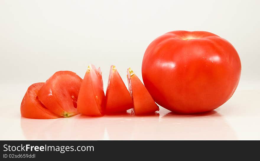 Tomato and pieces on a white background