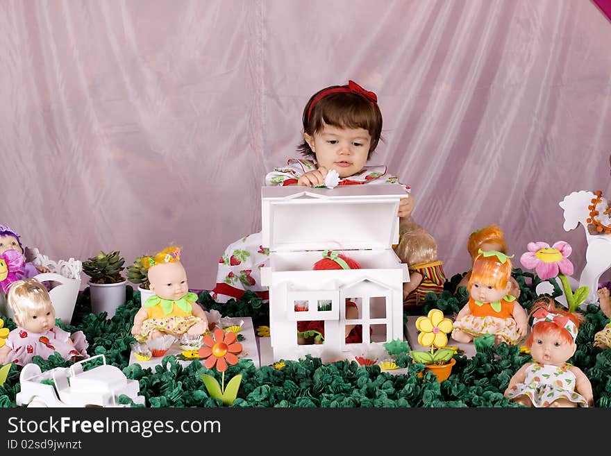 Baby girl opening a doll house and looking indside. Baby girl opening a doll house and looking indside