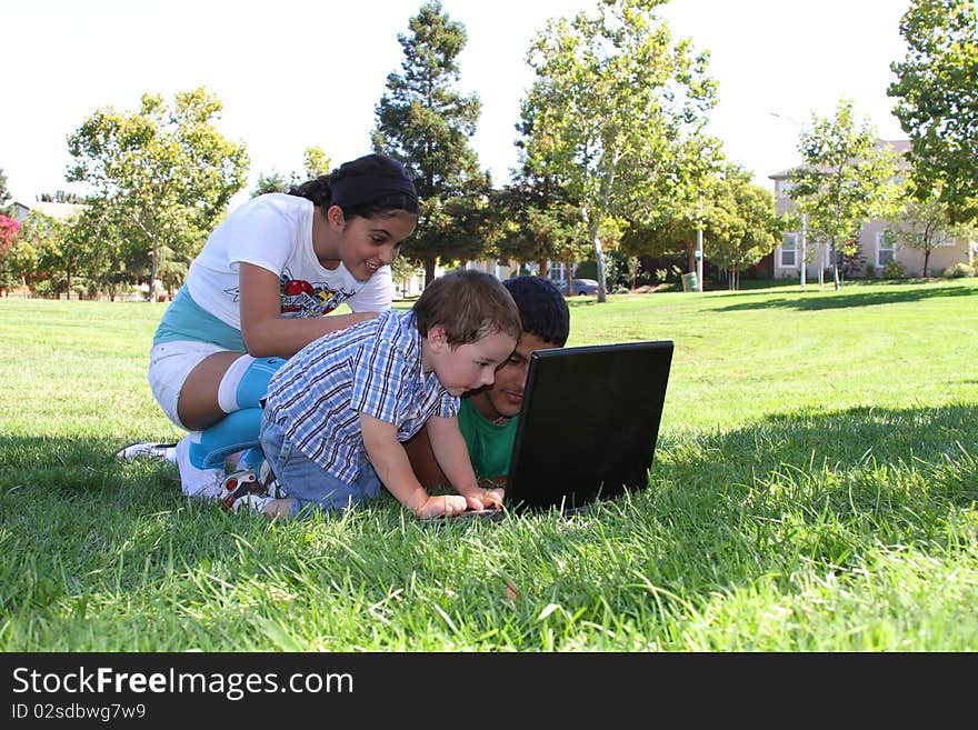 Children in the park with a laptop computer. Children in the park with a laptop computer