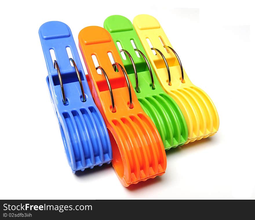 Four colorful clothes pegs in a row on white background