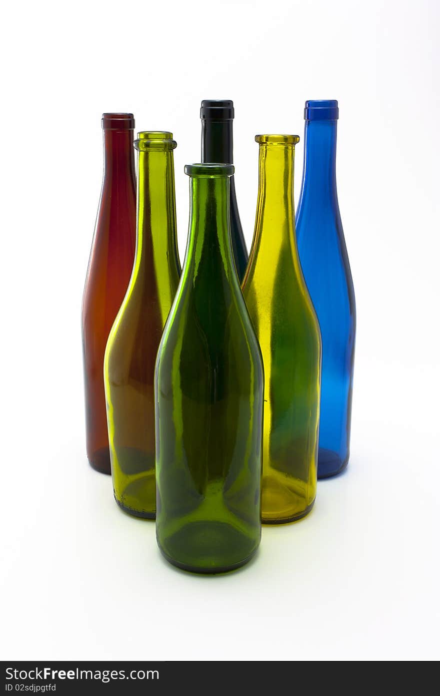 A collection of colorful glass wine bottles arranged in a triangle like bowling pins. A collection of colorful glass wine bottles arranged in a triangle like bowling pins.