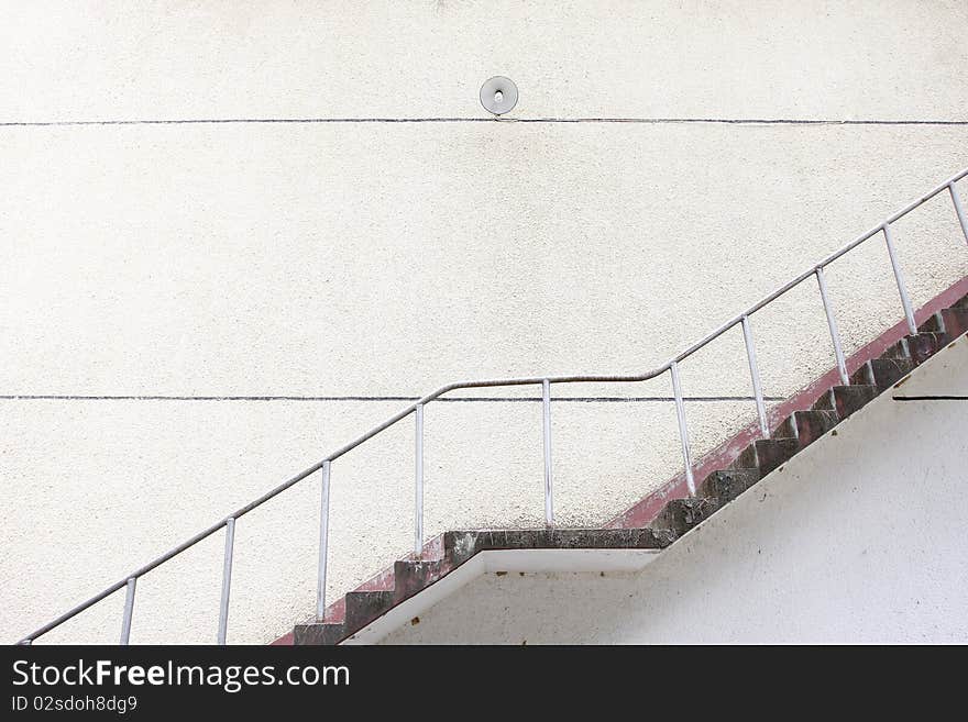 Closeup of concrete stairway with brick stairs and stucco walls