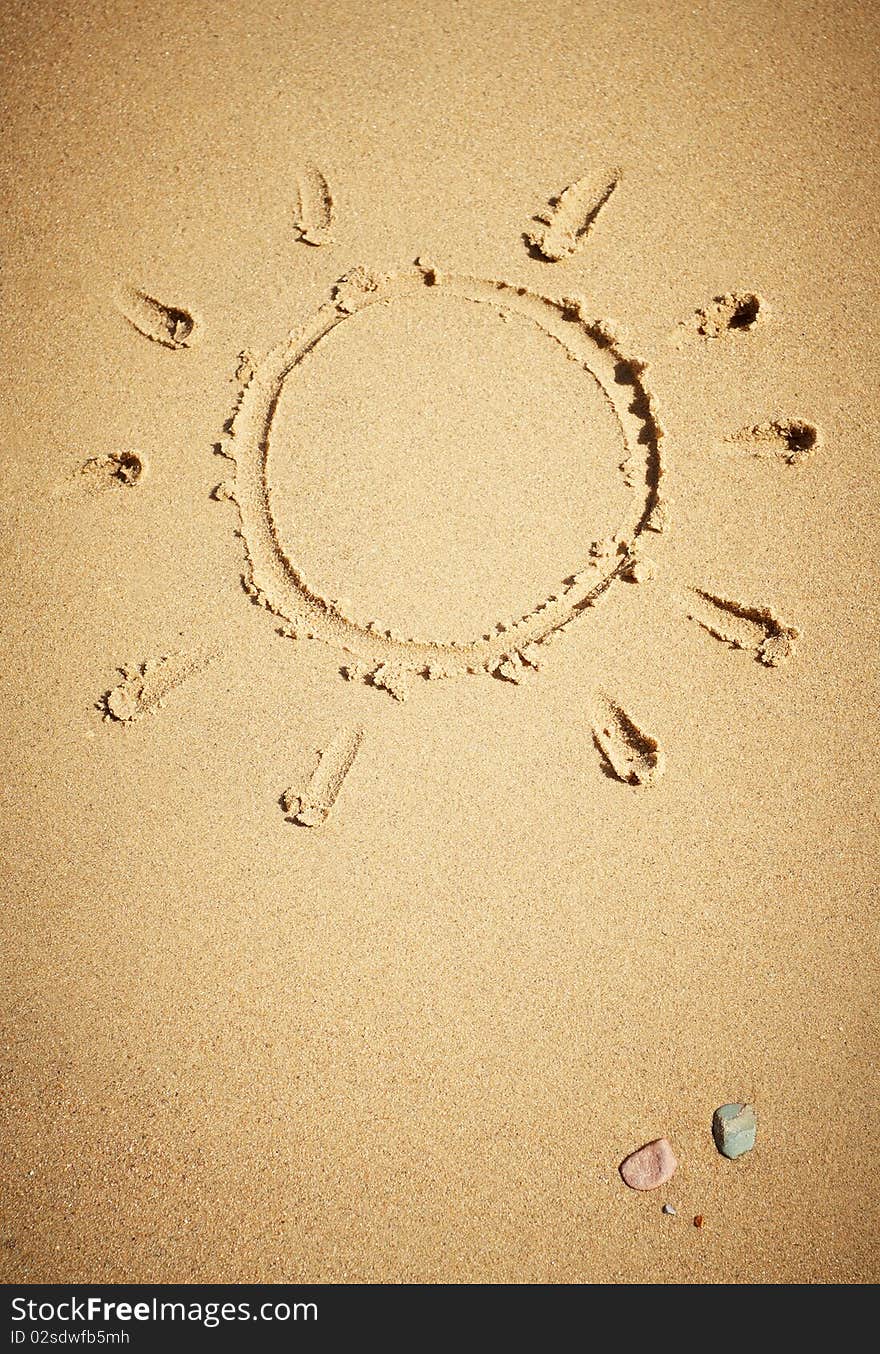 Sun drawn on sand, closeup shot.