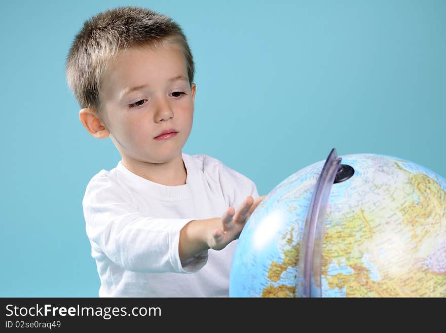 Photography with caucasian preschooler searching locations on globe. Photography with caucasian preschooler searching locations on globe