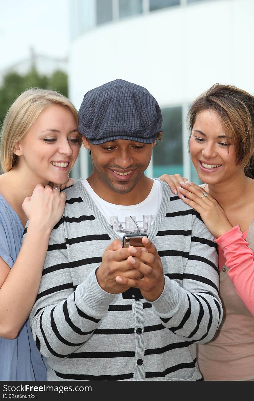 Group of friends sending message with mobile phone. Group of friends sending message with mobile phone