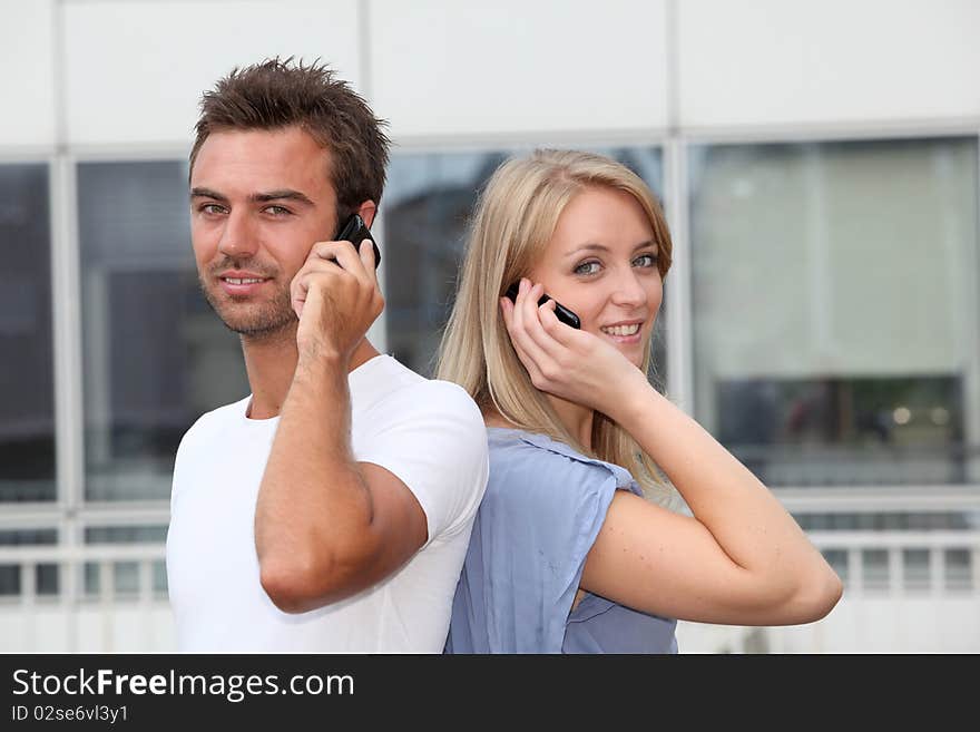 Couple standing outside with mobile phone. Couple standing outside with mobile phone