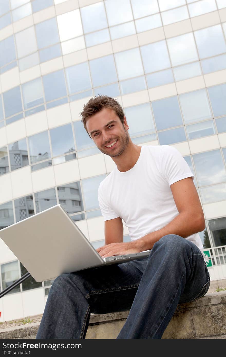 Smiling young man in front of building