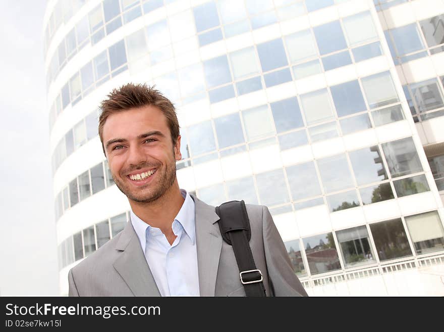 Closeup of businessman standing in front of offices building. Closeup of businessman standing in front of offices building