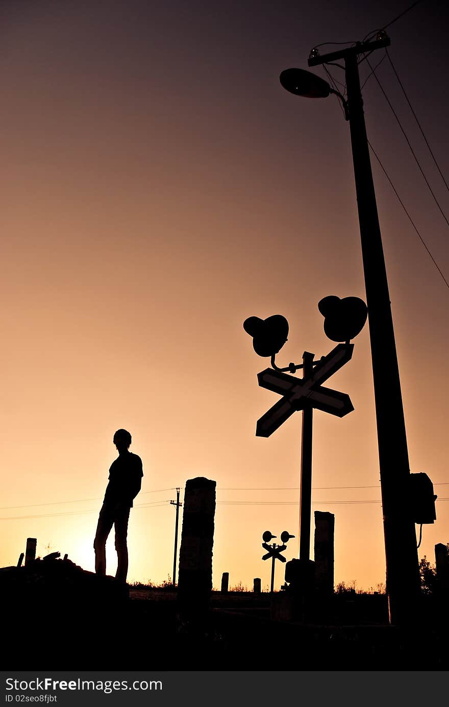 Silhouette of young man standing at summer sunset crossroad. Silhouette of young man standing at summer sunset crossroad