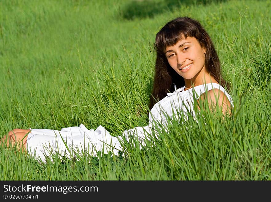 Smiling happy young girl on the meadow with green fresh grass. Smiling happy young girl on the meadow with green fresh grass