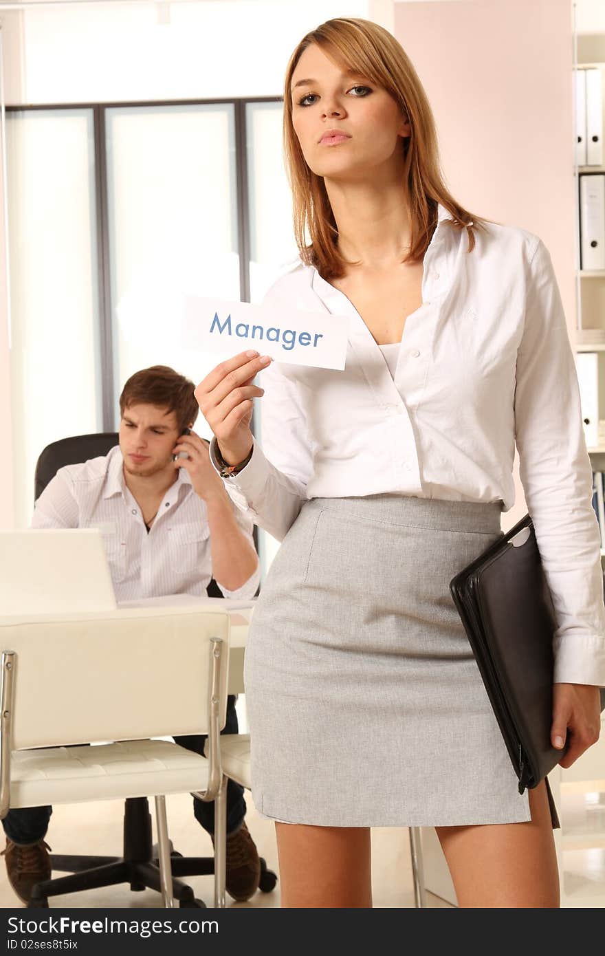 Business woman standing in front of a desk holding a plate. Business woman standing in front of a desk holding a plate