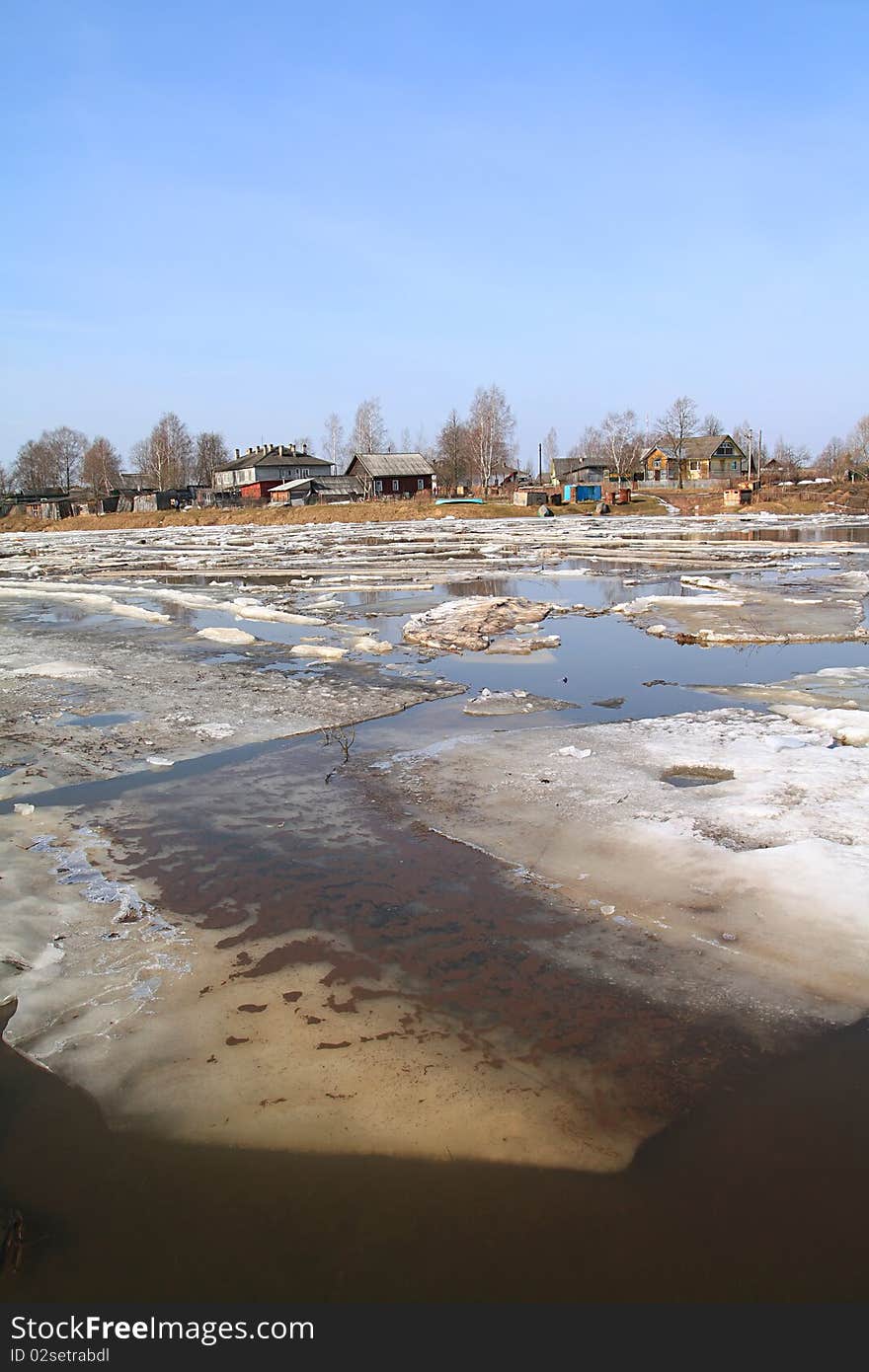 Driving of ice on small river against village