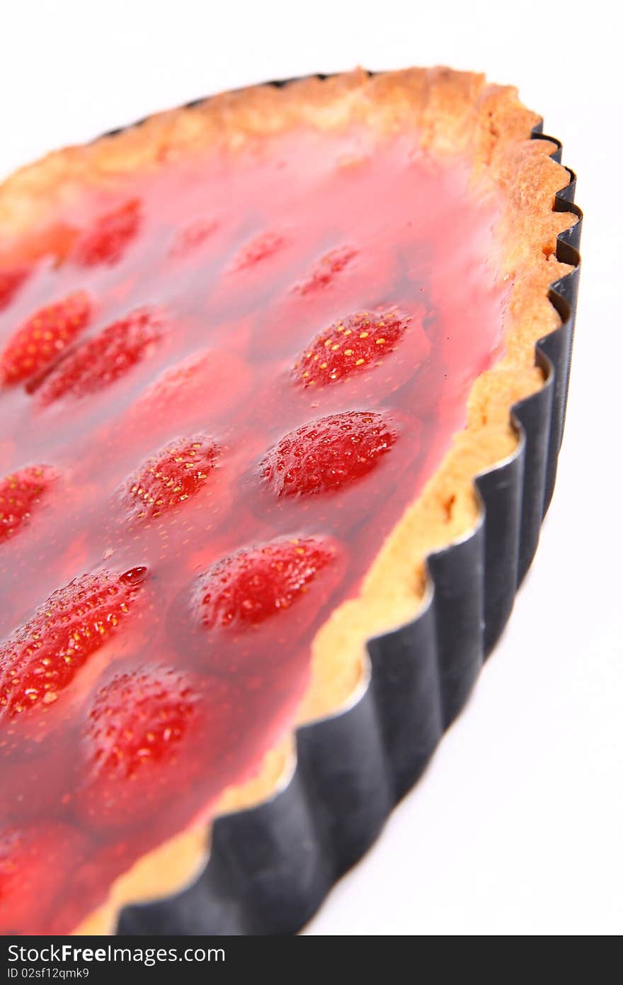 Strawberry Tart in a tart pan on a white background in close up