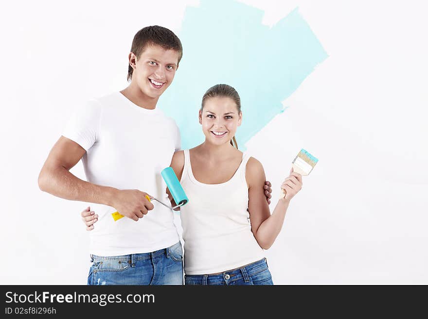 Attractive couple of brushes and rollers on the background of painted wall. Attractive couple of brushes and rollers on the background of painted wall