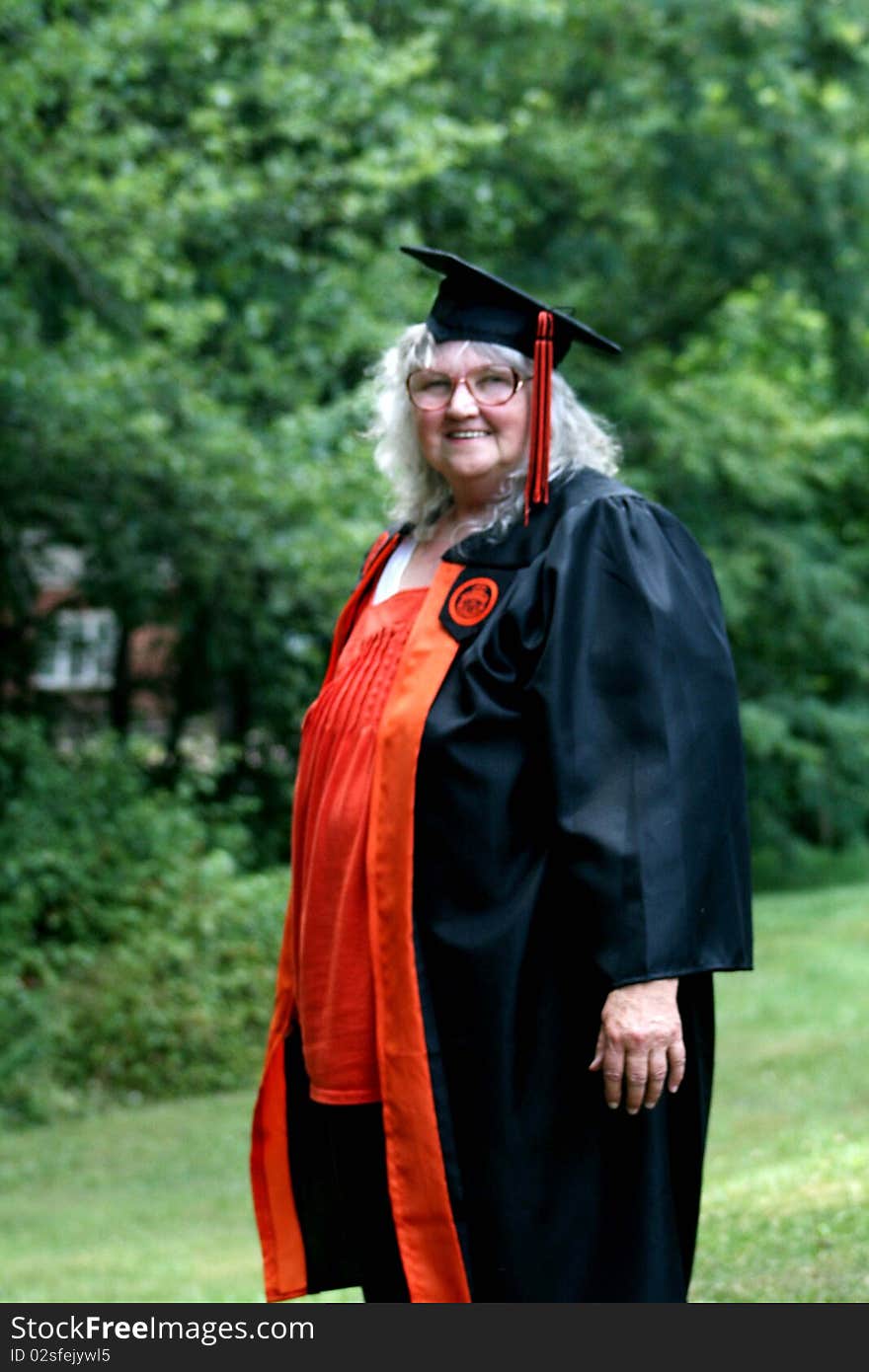 Elderly woman in cap and gown graduating college. Elderly woman in cap and gown graduating college