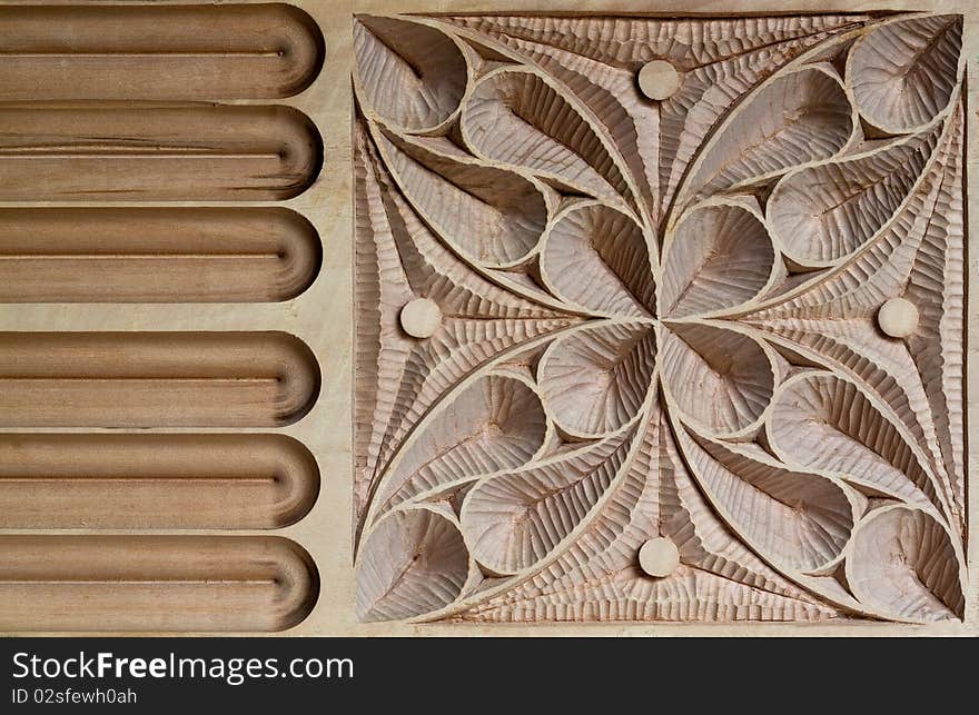 View of an Intricately carved wood panel, characterized by large and small sweeping curves and inspired by European medieval patterns.