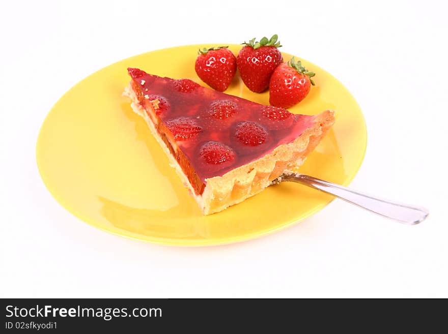 Piece of Strawberry Tart being put on a yellow plate decorated with strawberries with a cake server