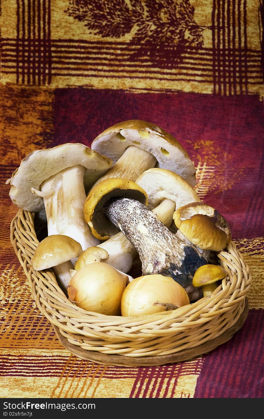 Basket with mushrooms and onions on colorful background