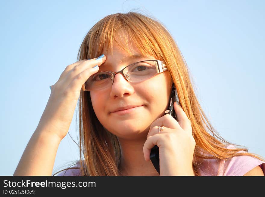 Young, red-haired girl talking on the phone. Young, red-haired girl talking on the phone