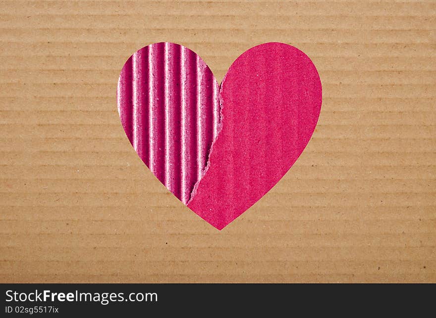 Pink paper hole in brown cardboard background