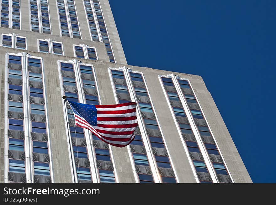 American flag contrasting with a blue sky and building. American flag contrasting with a blue sky and building.