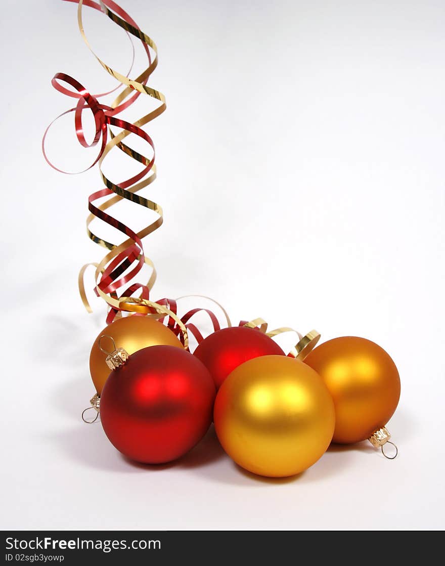 Yellow and red glass balls with ribbons on the white background. Yellow and red glass balls with ribbons on the white background