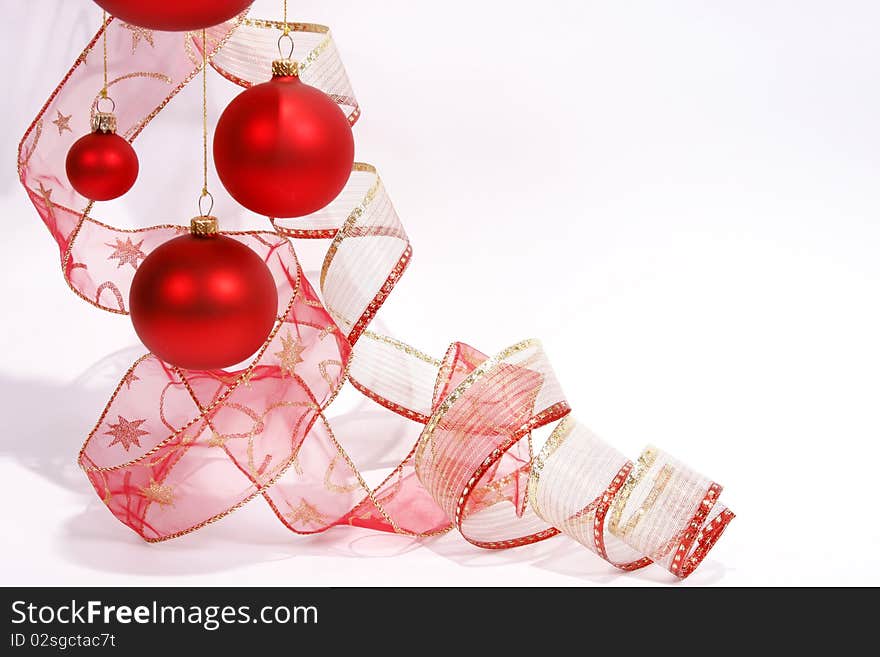 Hanging red glass balls with the ribbon on the white background. Hanging red glass balls with the ribbon on the white background