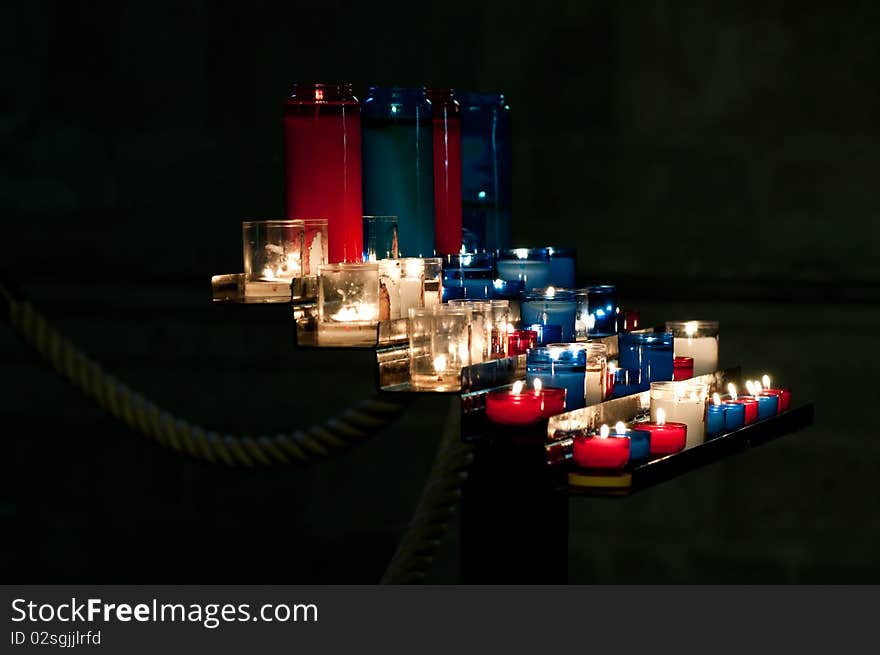 Red, blue and white prayer candles in a church in St. Malo, France