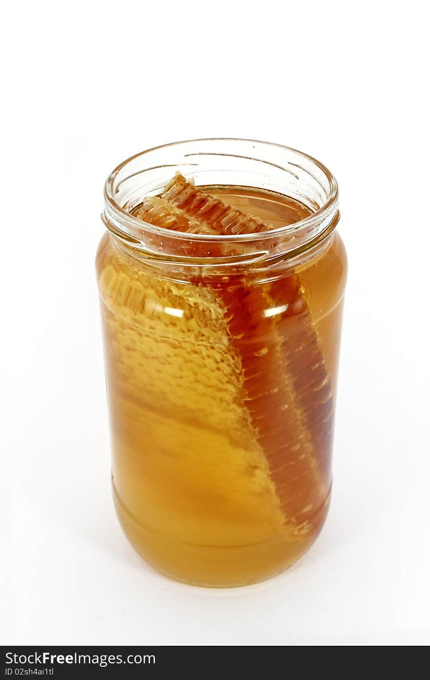 Glass jar full of honey with honeycomb, isolated on white. Glass jar full of honey with honeycomb, isolated on white