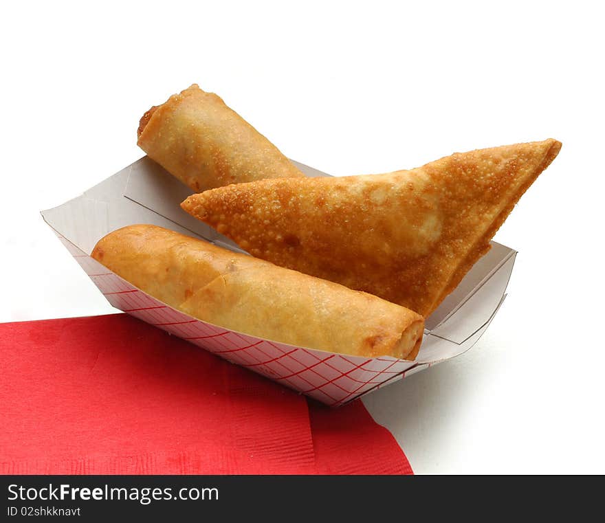 Two eggrolls and a wonton 
on red napkin 
on white background