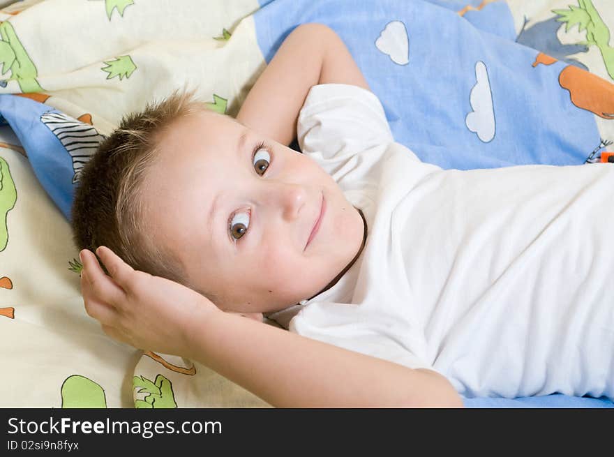 Little cute boy lying down on the bed