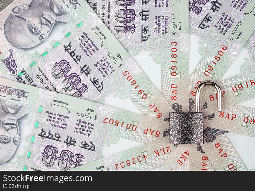 Open lock reflecting no security on Indian currency 100 rupee notes in a circular manner. Open lock reflecting no security on Indian currency 100 rupee notes in a circular manner