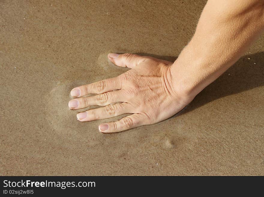 Human hand on beach sand. Human hand on beach sand.