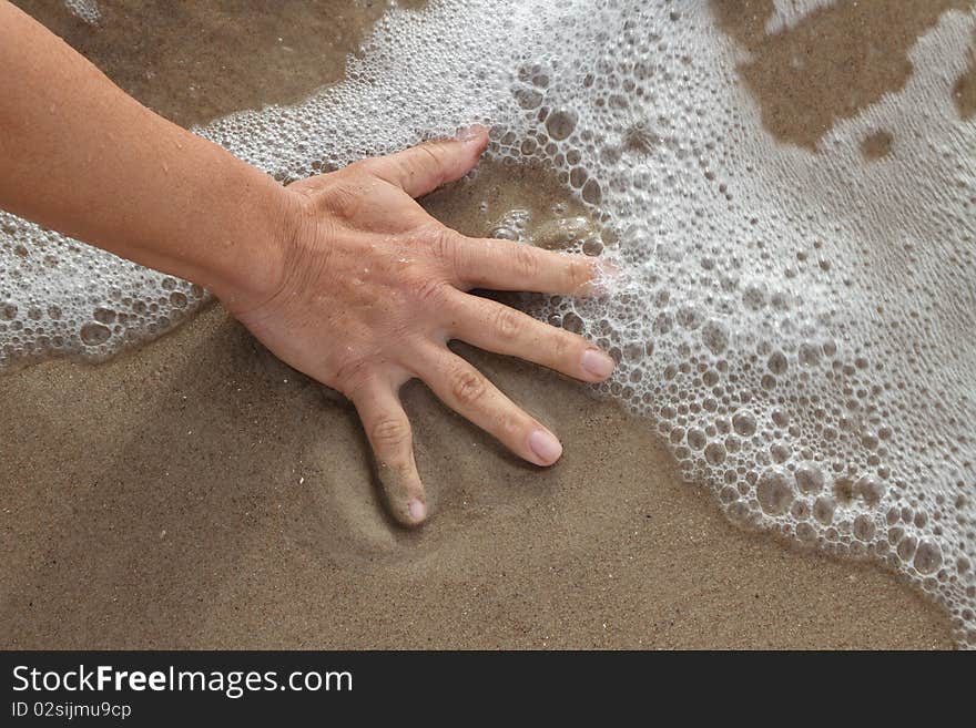 Human hand on beach sand. Human hand on beach sand.