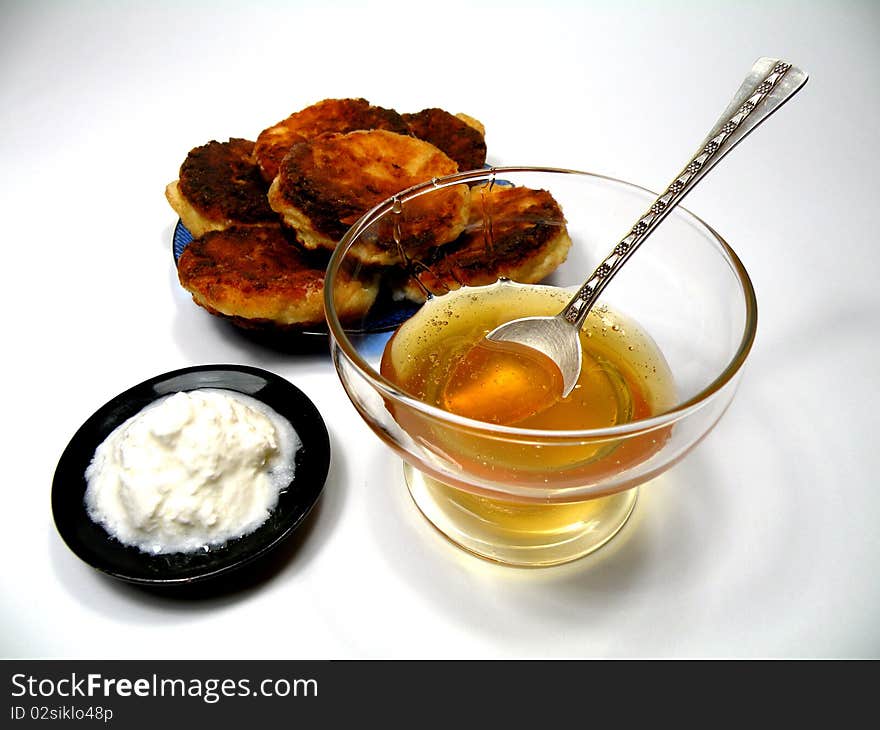 Honey and cheese bowl with a spoon of honey and cheese pancakes on a plate