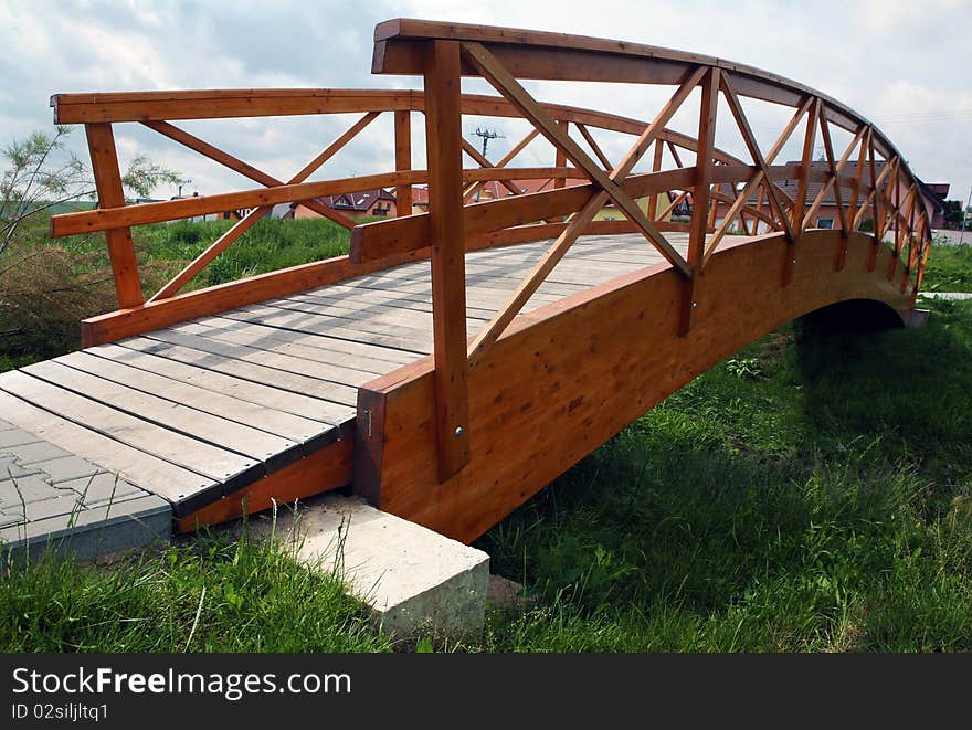 Wooden bridge over the small grassy ditch