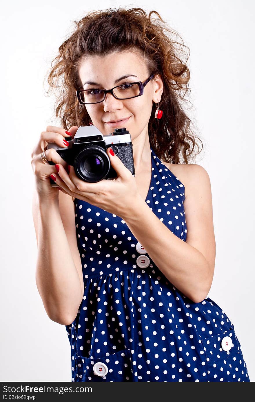 Beautiful woman in a blue polka dot dress with camera