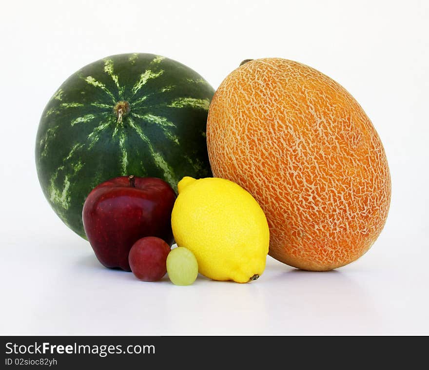 Watermelon, yellow melon, apple, lemon, and grapes looking like couples isolated on white background. Watermelon, yellow melon, apple, lemon, and grapes looking like couples isolated on white background