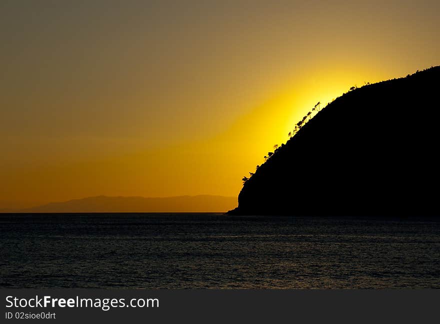 An orange and yellow sunset over a calm sea. An orange and yellow sunset over a calm sea