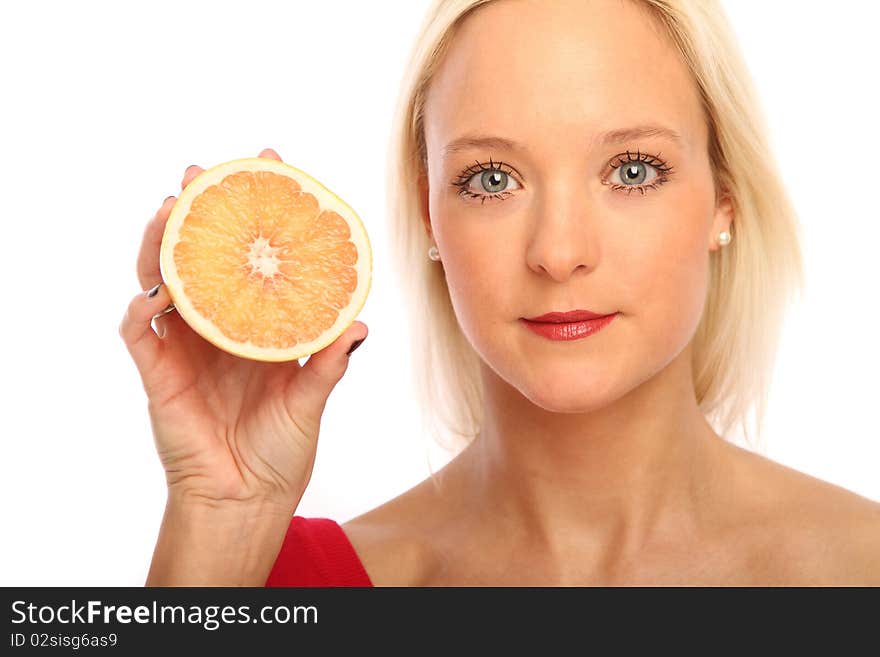 Young blond woman showing a half grapefruit. Young blond woman showing a half grapefruit