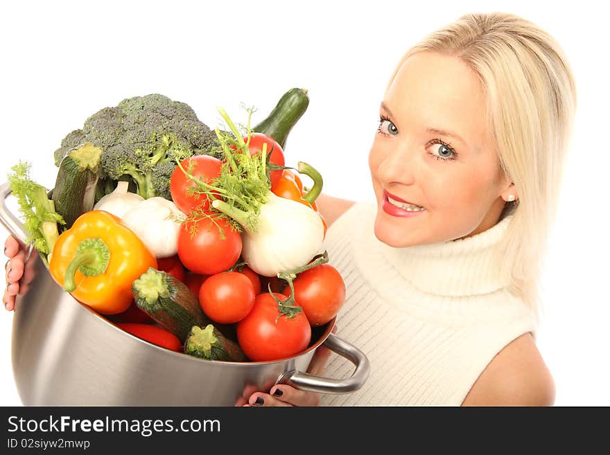 Young blond woman holding some different fresh vegetables. Young blond woman holding some different fresh vegetables