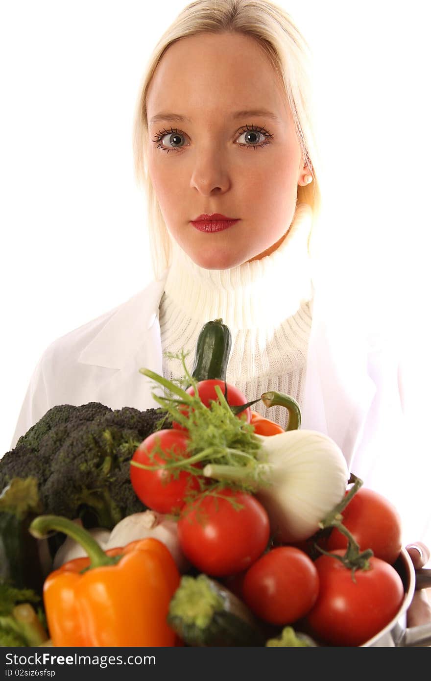 Young blond woman holding some different fresh vegetables. Young blond woman holding some different fresh vegetables