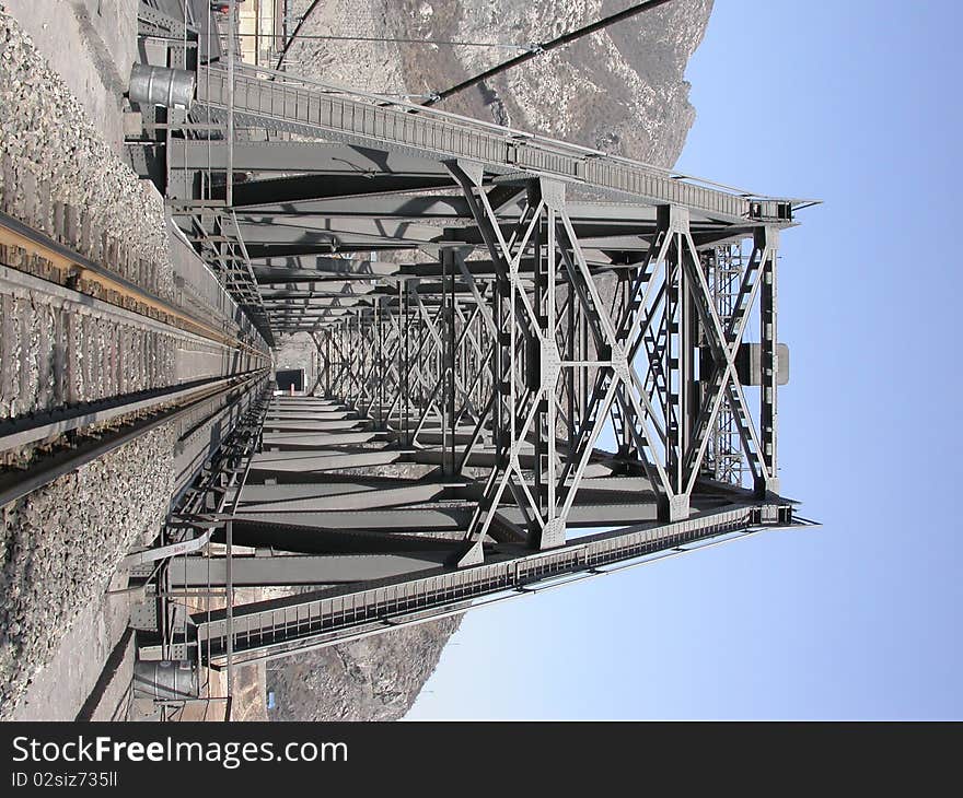 Steel railway bridge into tunnel in the moutain